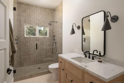a bathroom with a sink a toilet and shower