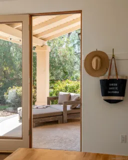 a view of a backyard with lawn chairs under an umbrella