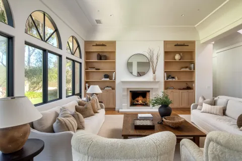 a living room with furniture a fireplace and a large window