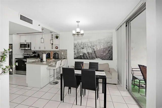 a kitchen with kitchen island granite countertop a table chairs microwave and cabinets