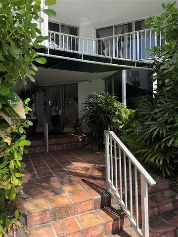 a view of a house with brick walls and flower plants