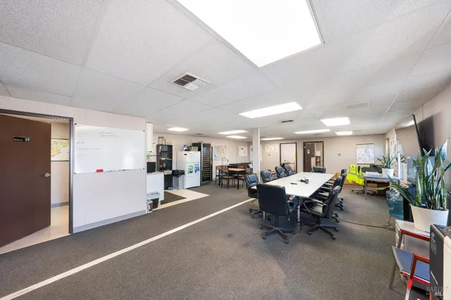 a kitchen with stainless steel appliances granite countertop a refrigerator a sink dishwasher a stove and white cabinets with wooden floor