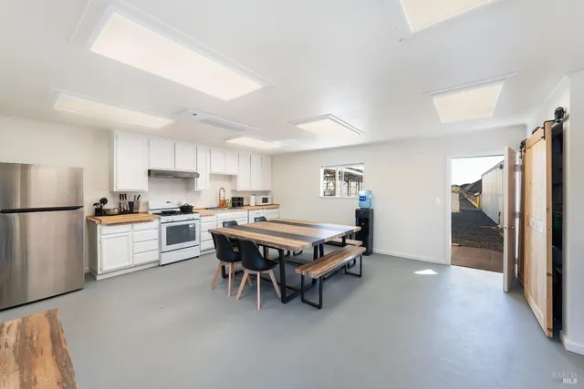 a living room with furniture and a dining table with kitchen view