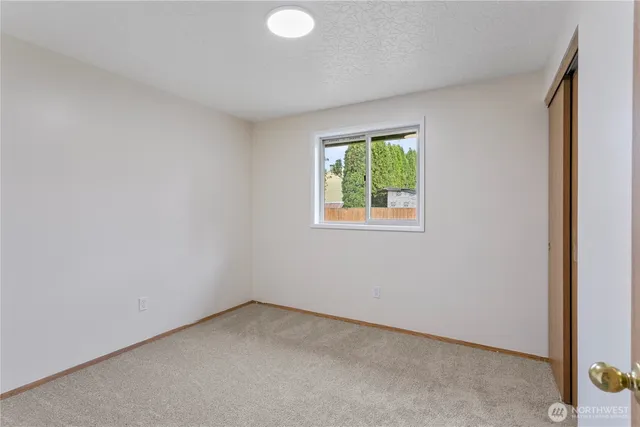 an empty room with windows and closet