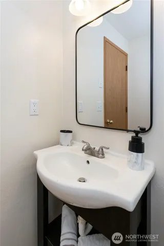 a bathroom with a granite countertop sink and a mirror with toilet