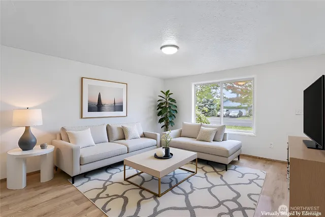 a living room with furniture a flat screen tv and a window
