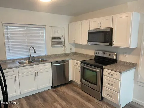 a kitchen with white cabinets stainless steel appliances and sink