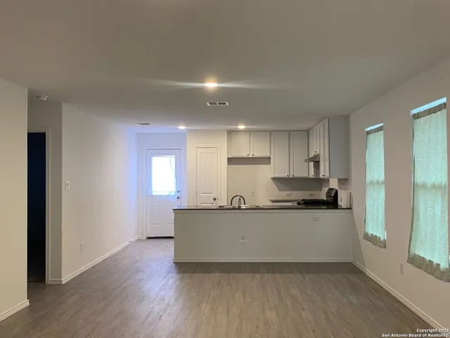 a large white kitchen with wooden floors and white walls