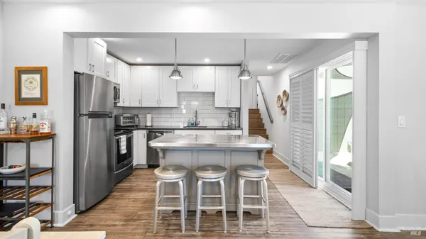 a kitchen with kitchen island granite countertop a counter space dining table and stainless steel appliances
