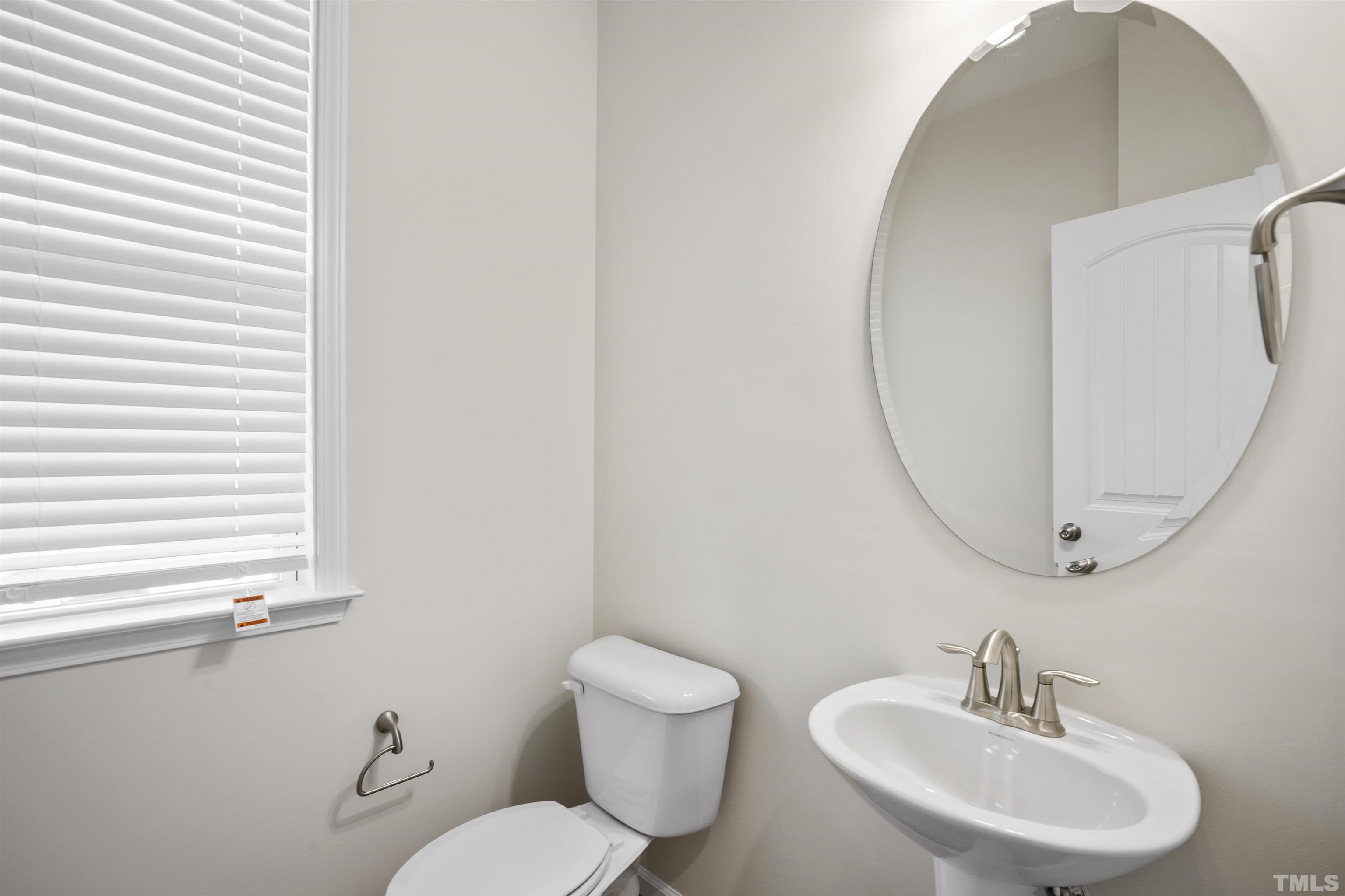 516 Gianna Drive, Unit 449 Clayton, NC 27527 - Photo 8 of 21 a bathroom with a toilet a sink and mirror