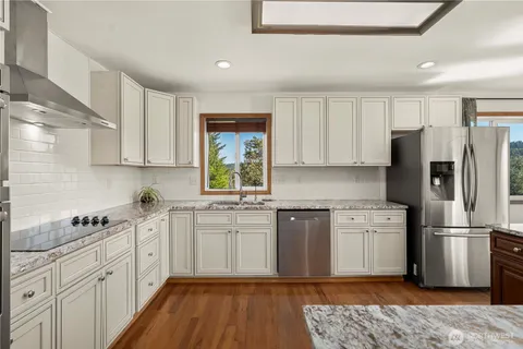 a kitchen with stainless steel appliances a refrigerator sink and cabinets