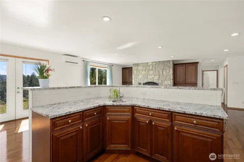 a kitchen with granite countertop a sink and a wooden floor