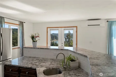 a bathroom with a granite countertop sink and a window