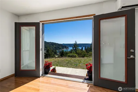 a living room with a floor to ceiling window and wooden floor