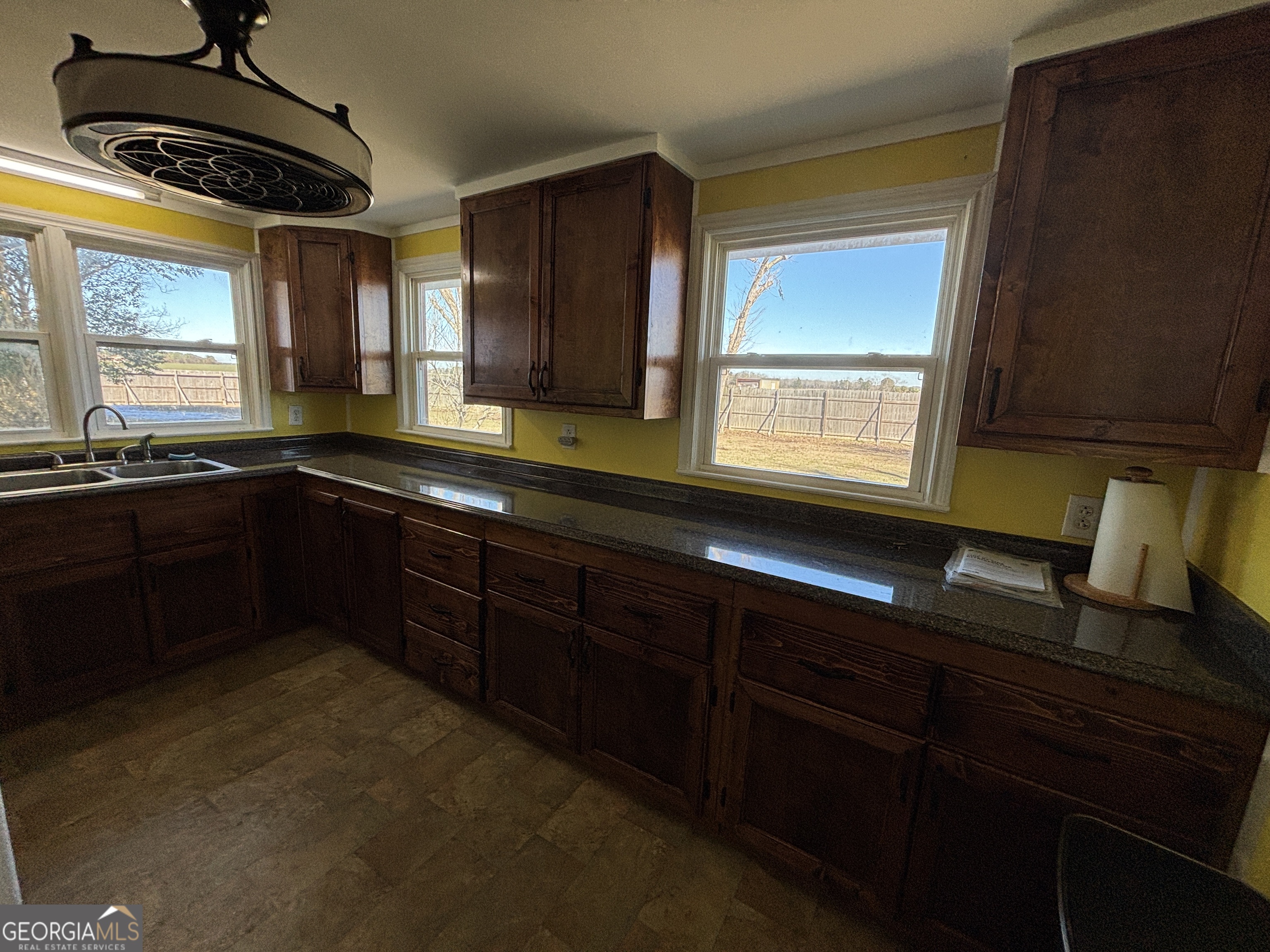 231 Barlow Road Cochran, GA 31014 - Photo 26 of 65 a kitchen with granite countertop stainless steel appliances a sink window and cabinets
