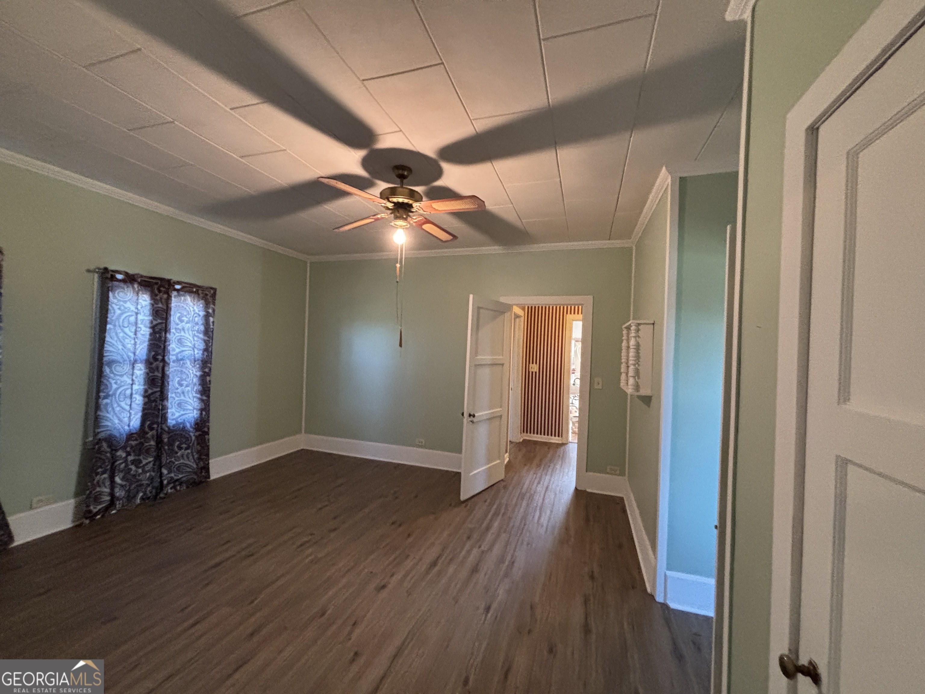 231 Barlow Road Cochran, GA 31014 - Photo 45 of 65 a view of an empty room with wooden floor and a ceiling fan