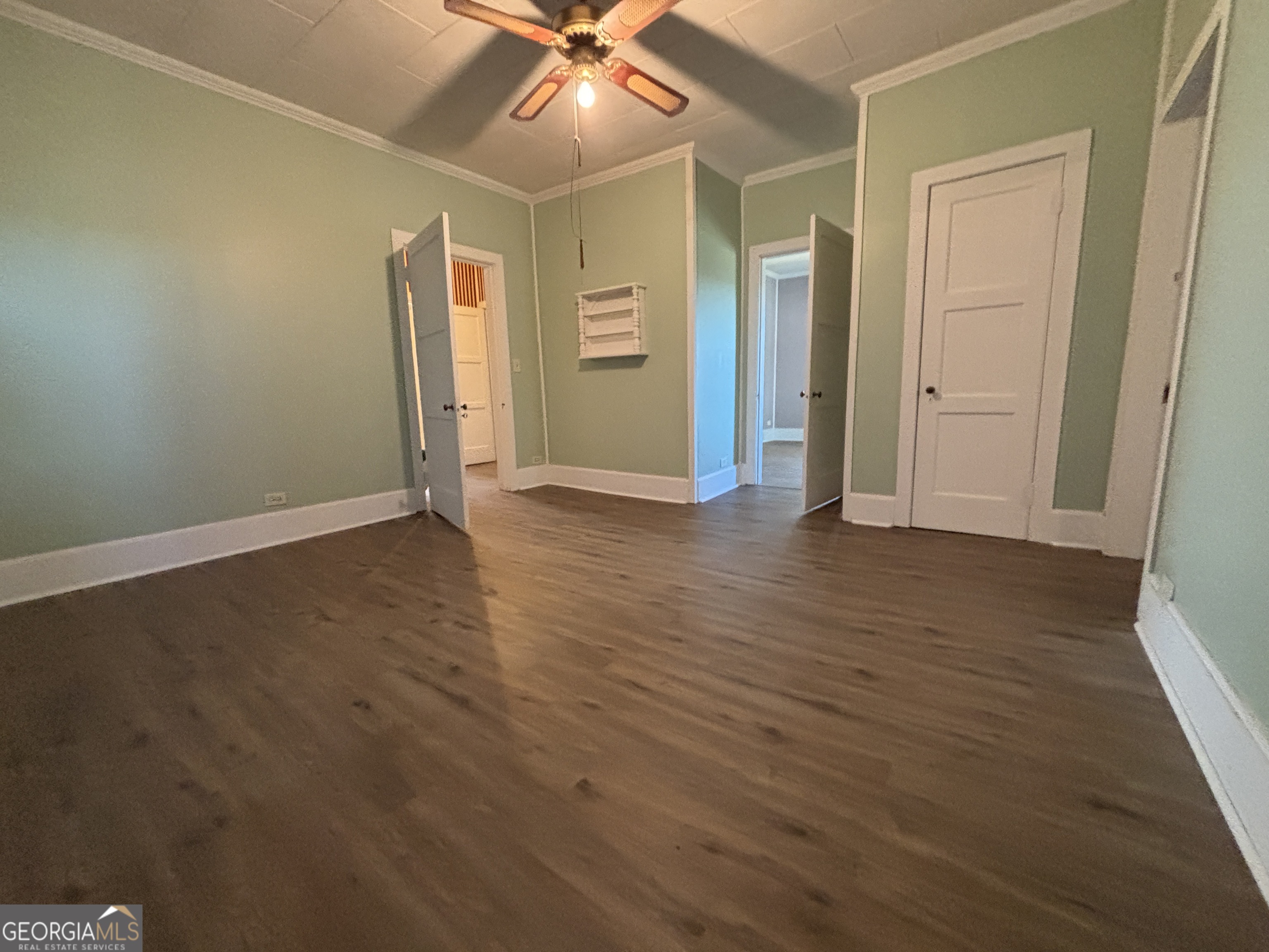 231 Barlow Road Cochran, GA 31014 - Photo 46 of 65 an empty room with wooden floor and a ceiling fan