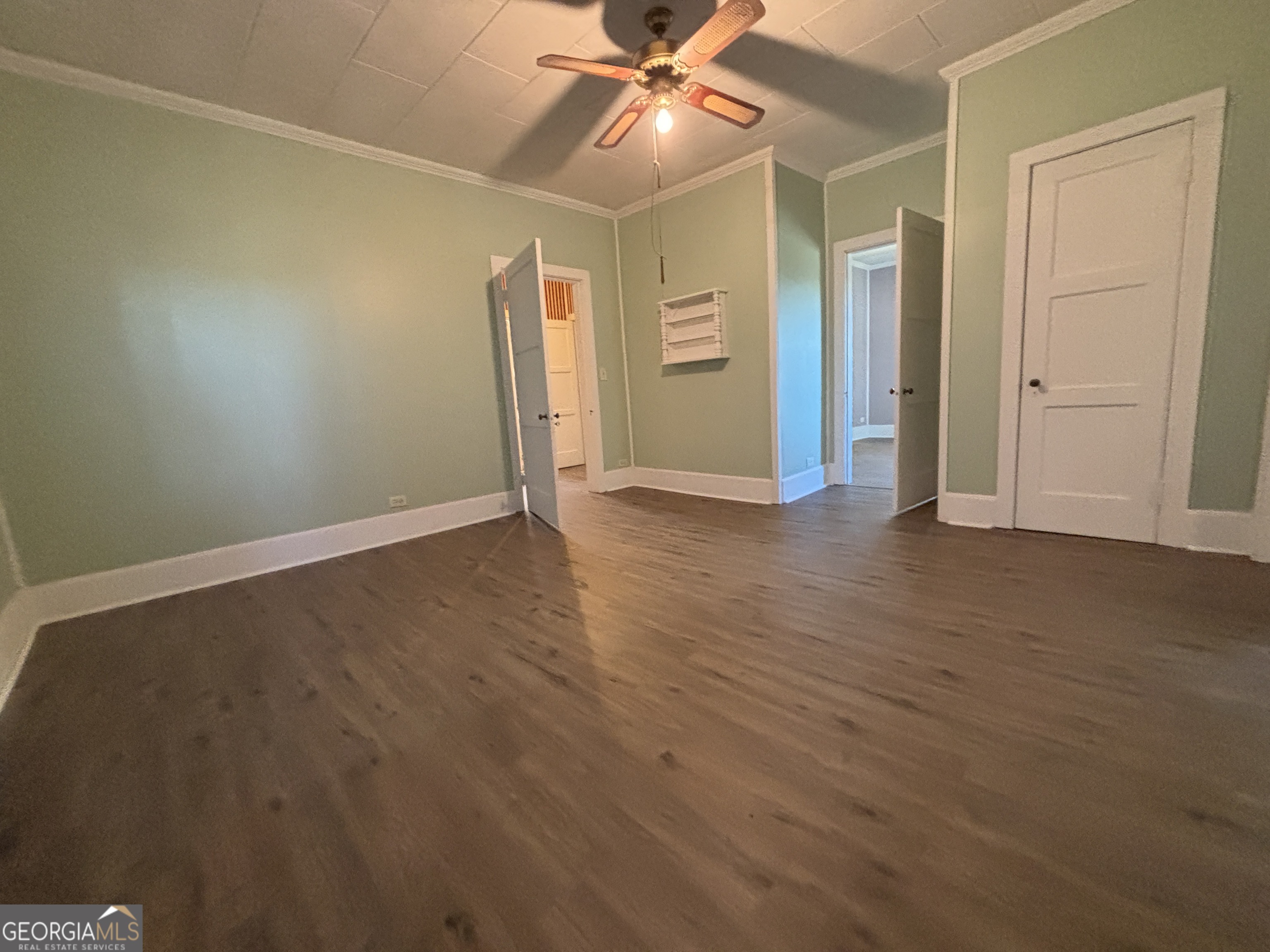 231 Barlow Road Cochran, GA 31014 - Photo 47 of 65 an empty room with wooden floor and ceiling fan