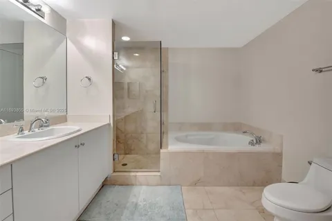 a bathroom with a bathtub shower sink vanity and toilet
