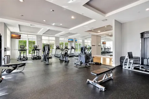 a living room with couches a large dining table and chairs with wooden floor