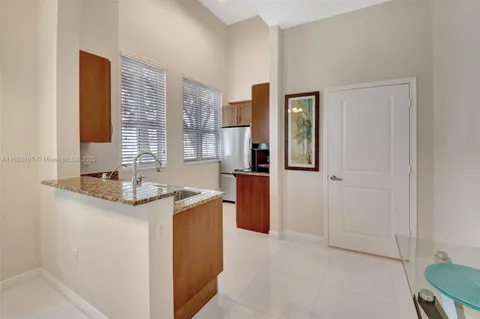 a kitchen with stainless steel appliances granite countertop a sink and a refrigerator