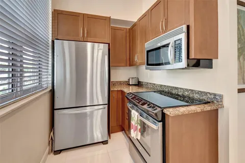 a kitchen with stainless steel appliances granite countertop a refrigerator a microwave a sink and a stove