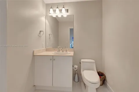 a bathroom with a toilet a sink and mirror