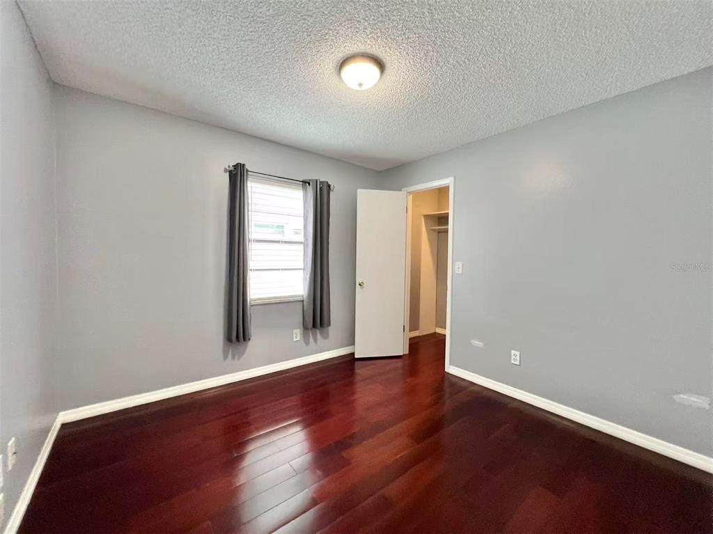8341 Duval Drive Port Richey, FL 34668 - Photo 21 of 27 an empty room with wooden floor and windows