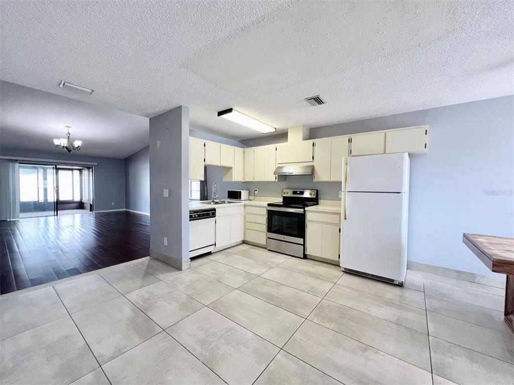 8341 Duval Drive Port Richey, FL 34668 - Photo 4 of 27 a kitchen with granite countertop a refrigerator and a stove top oven