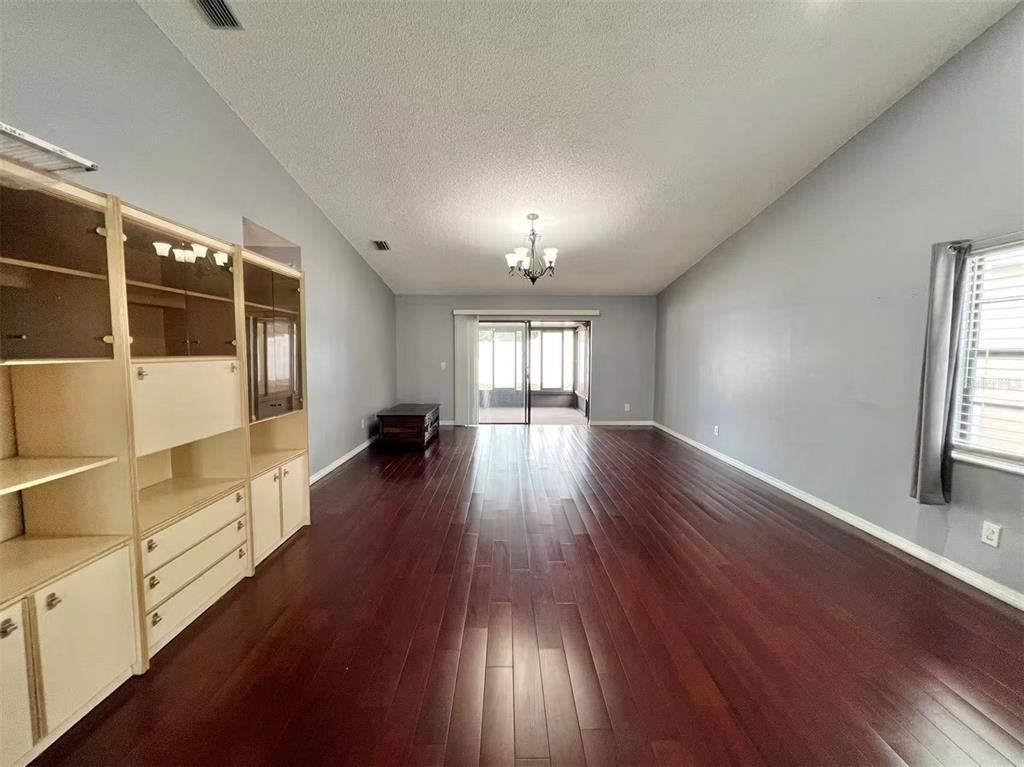 8341 Duval Drive Port Richey, FL 34668 - Photo 8 of 27 wooden floor in an empty room with a window