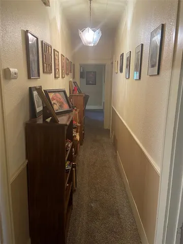 a view of a livingroom with furniture and a hallway