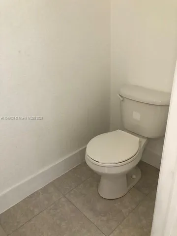 a white toilet sitting next to a white wall