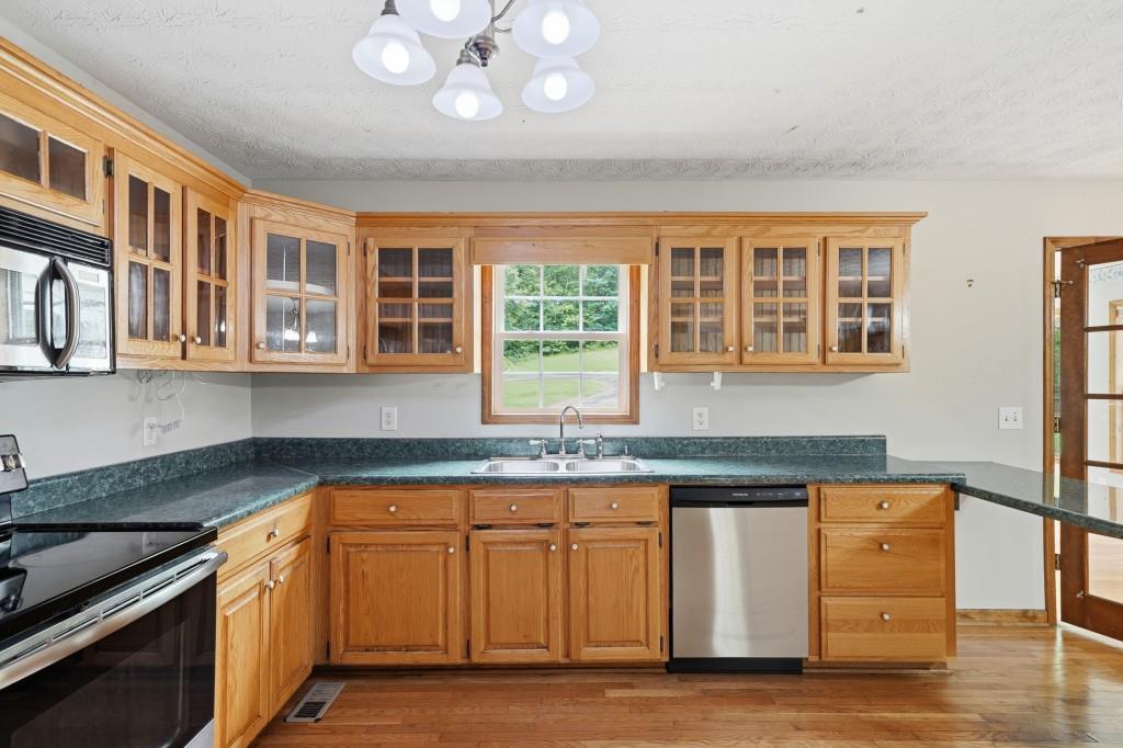 176 Big Oak Tree Road Northwest Adairsville, GA 30103 - Photo 19 of 77 a kitchen with granite countertop cabinets stainless steel appliances and a counter space