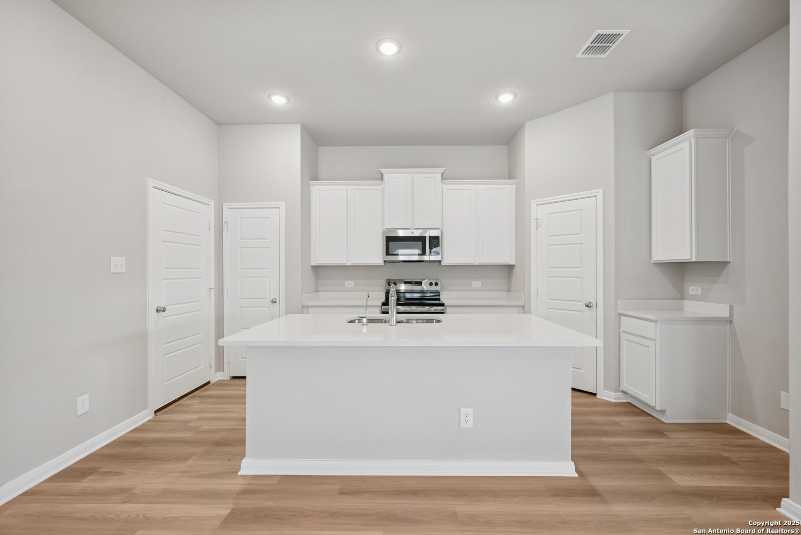 2825 Sun Bayou Seguin, TX 78155 - Photo 3 of 40 a view of a kitchen with kitchen island a sink wooden floor and stainless steel appliances