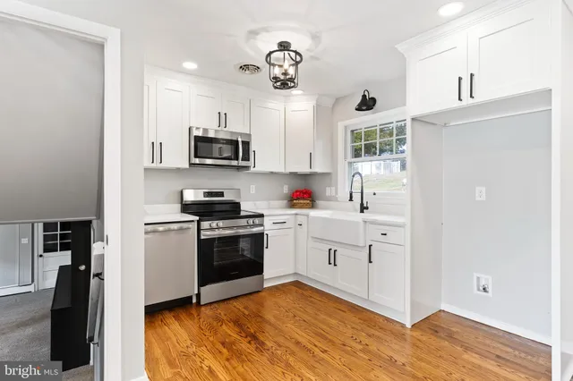 a kitchen with granite countertop a refrigerator stove top oven and sink