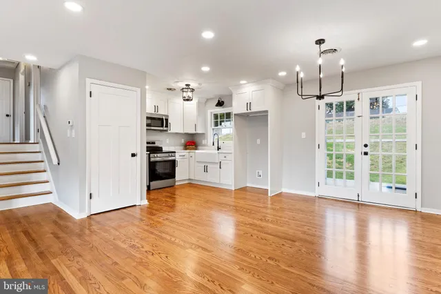 a view of a kitchen with stainless steel appliances wooden floor and a window