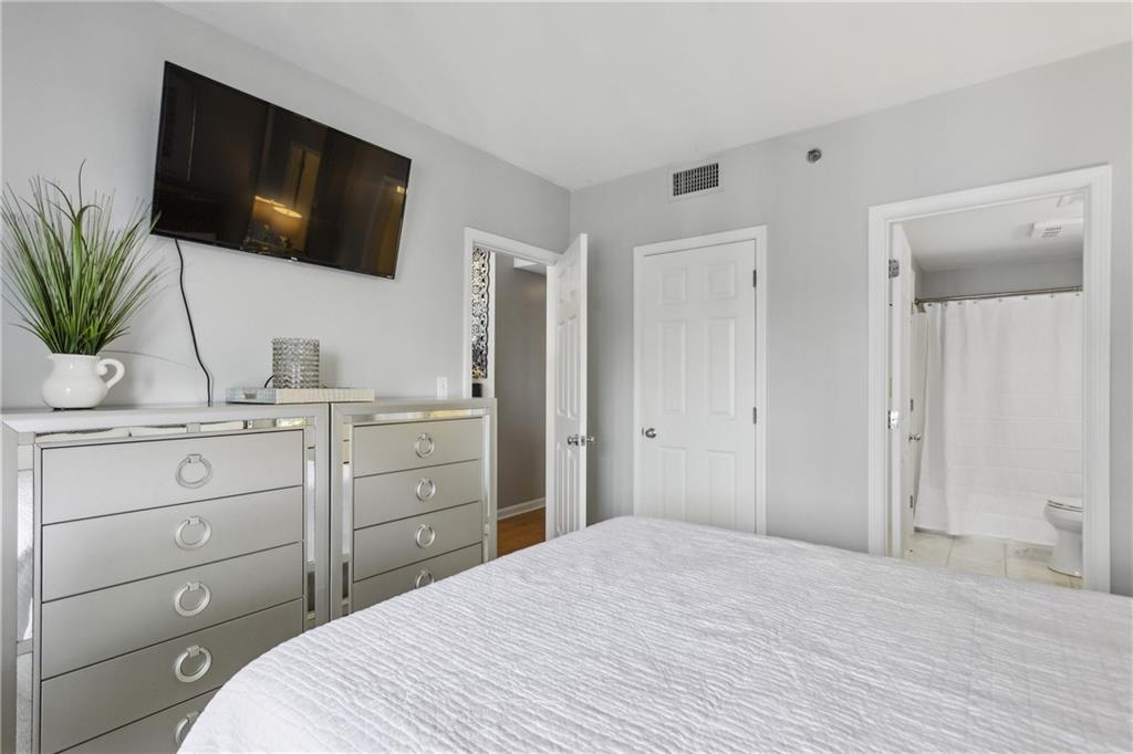 3481 Lakeside Drive Northeast, Unit 3004 Atlanta, GA 30326 - Photo 12 of 14 a bedroom with a bed and a flat screen tv