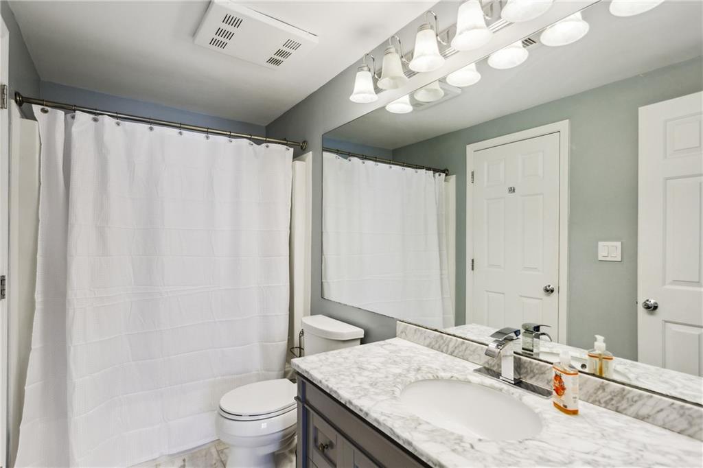 3481 Lakeside Drive Northeast, Unit 3004 Atlanta, GA 30326 - Photo 14 of 14 a bathroom with a granite countertop sink a toilet and a mirror