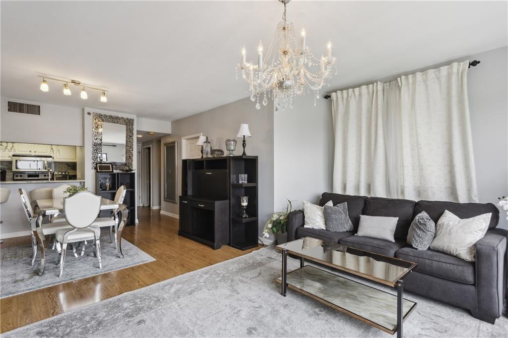 3481 Lakeside Drive Northeast, Unit 3004 Atlanta, GA 30326 - Photo 2 of 14 a living room with furniture a chandelier and a dining table