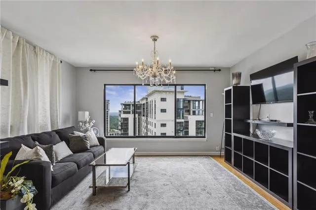a living room with furniture a chandelier and a flat screen tv