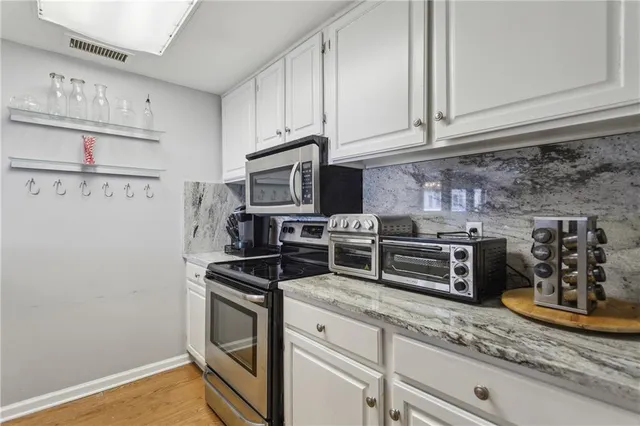 a kitchen with granite countertop stainless steel appliances and wooden cabinets