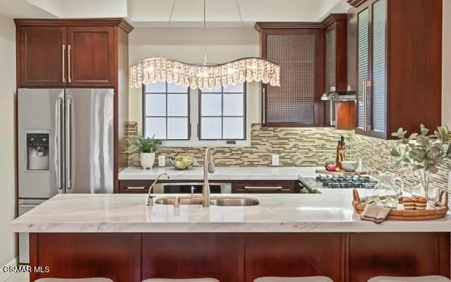 a kitchen with stainless steel appliances kitchen island granite countertop a refrigerator and a stove