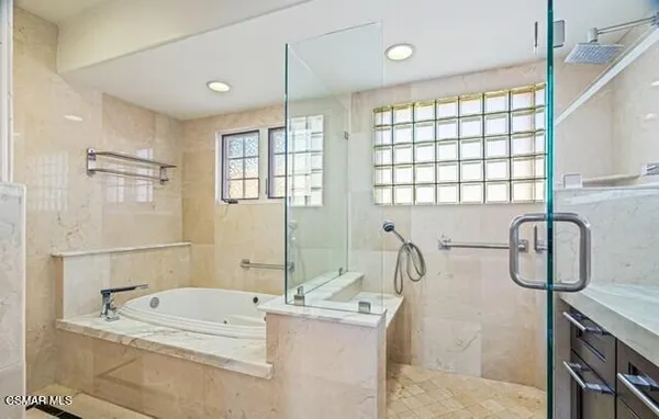 a bathroom with a granite countertop sink a large mirror and a bathtub