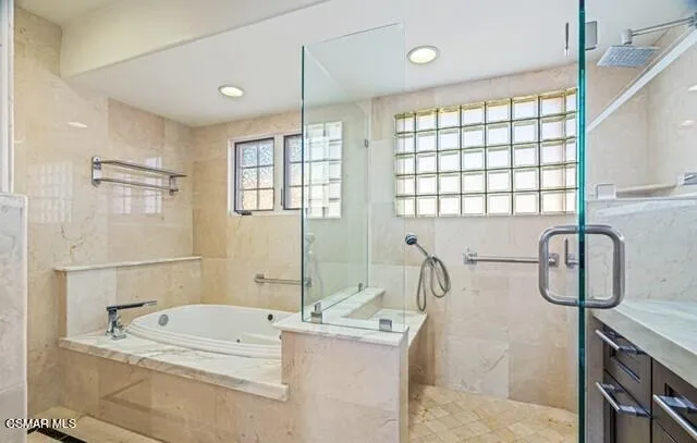 a bathroom with a granite countertop sink a large mirror and a bathtub