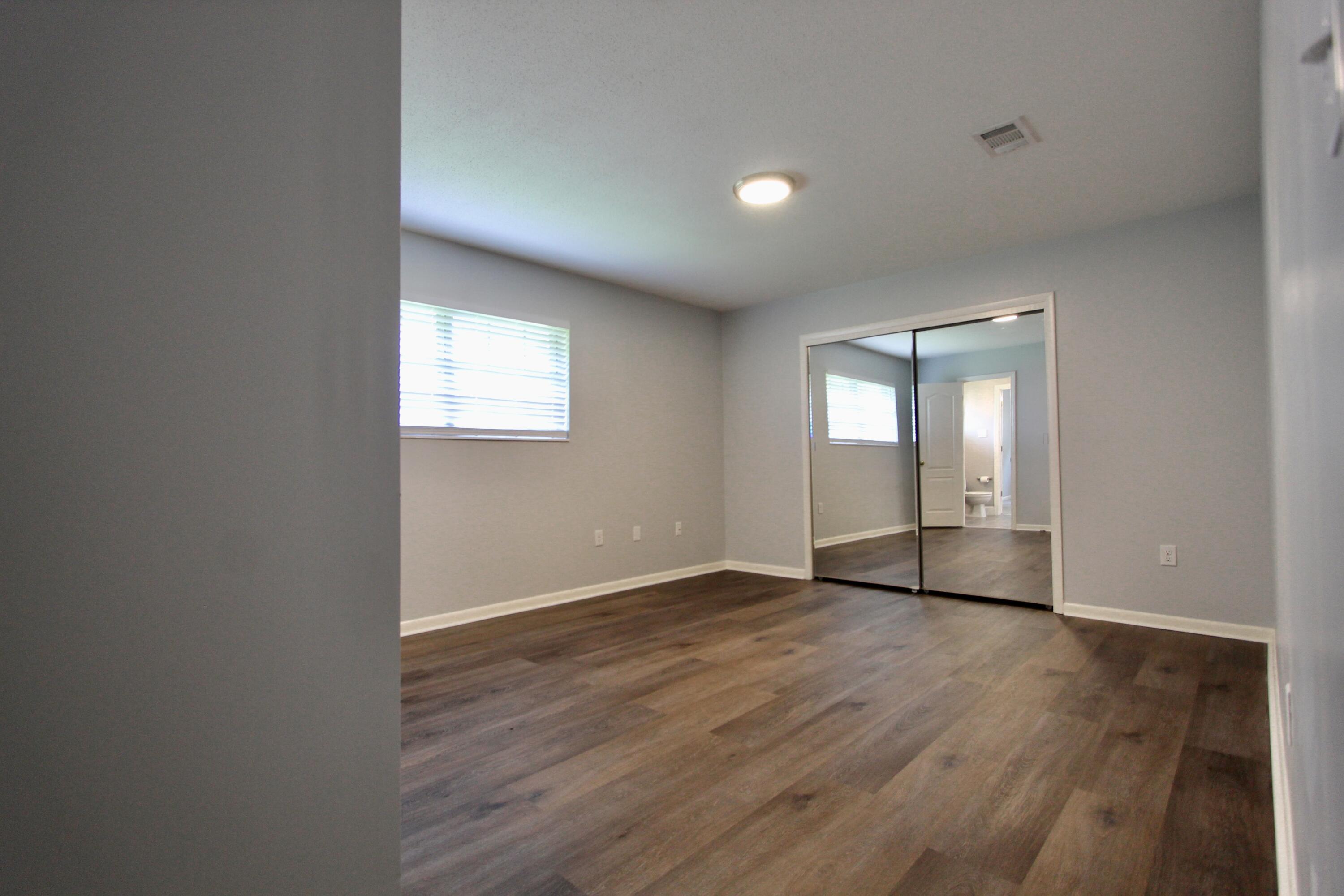 35 Birch Avenue Shalimar, FL 32579 - Photo 14 of 35 an empty room with wooden floor and mirror