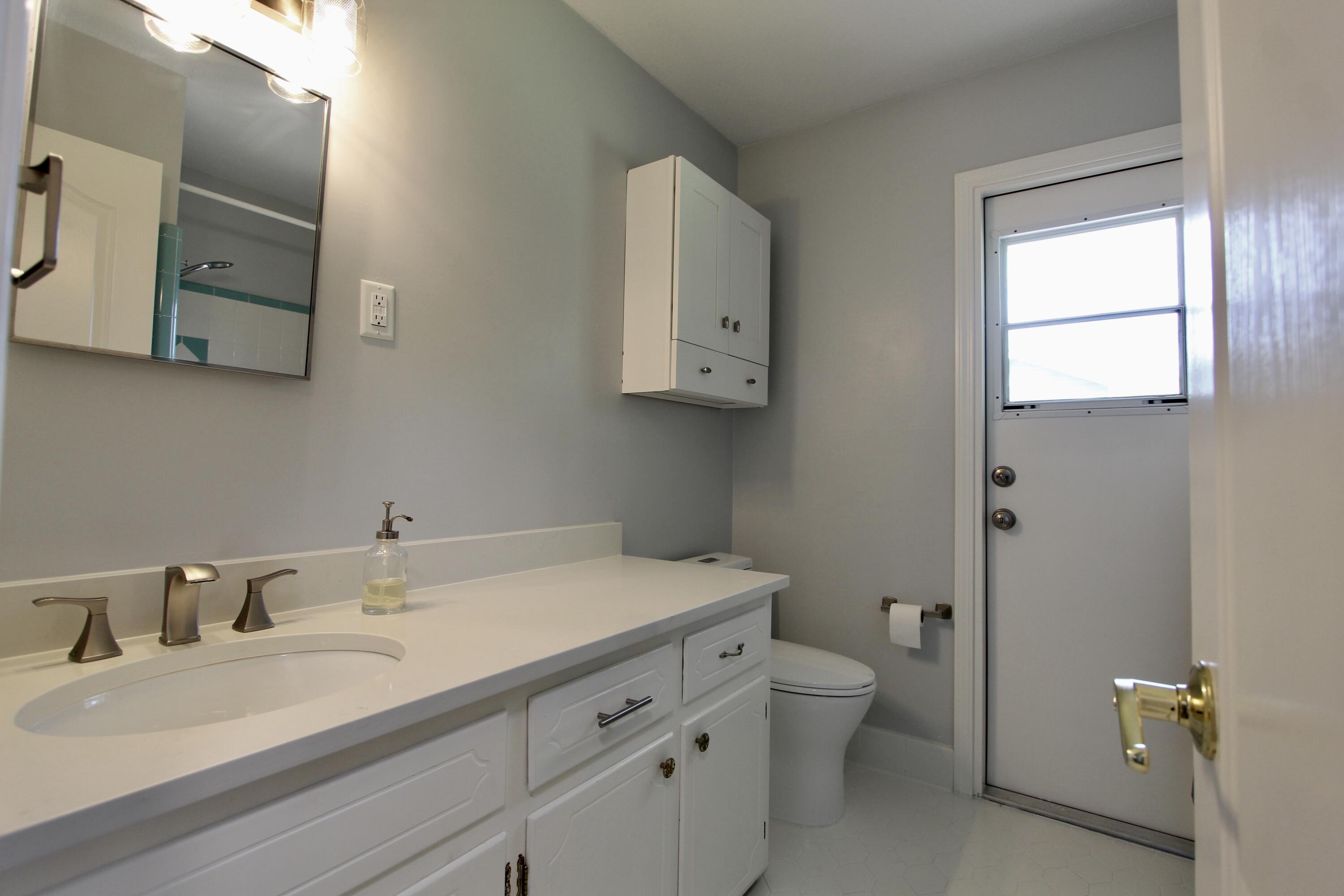 35 Birch Avenue Shalimar, FL 32579 - Photo 21 of 35 a bathroom with a granite countertop sink a toilet and a mirror