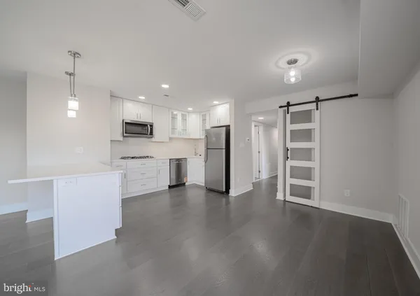 a view of kitchen with wooden floor and electronic appliances