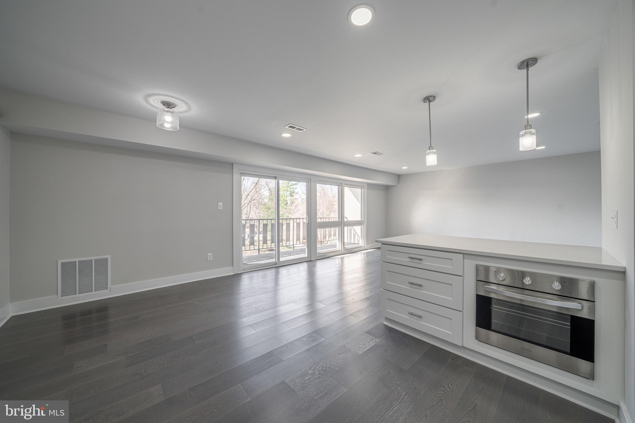 3122 Brinkley Road, Unit 102 Temple Hills, MD 20748 - Photo 14 of 44 a view of an empty room with wooden floor and a window