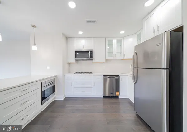 a kitchen with white cabinets and stainless steel appliances