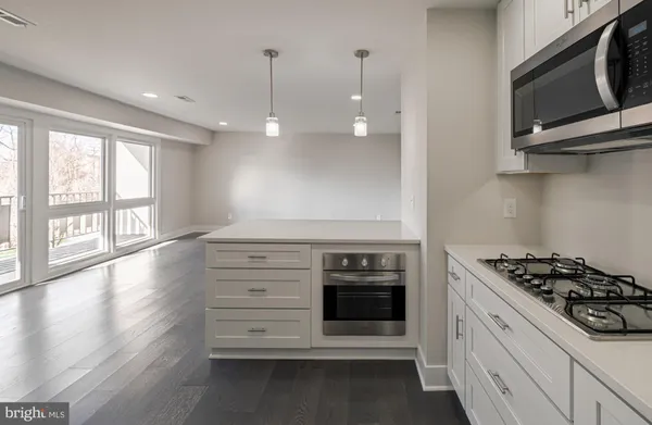 a kitchen with stainless steel appliances a stove and a microwave